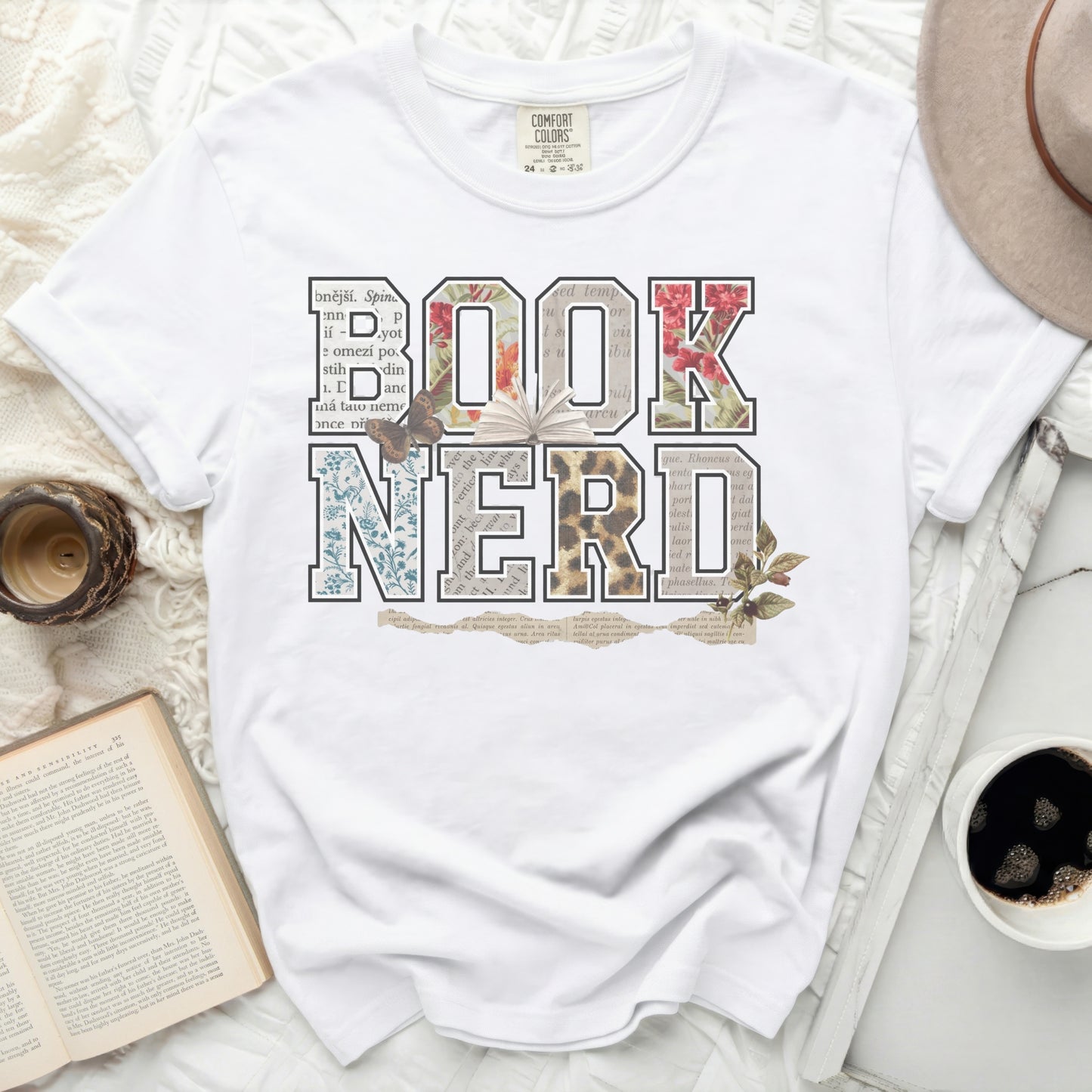 White t-shirt with "BOOK NERD" in floral and newspaper-print letters.
