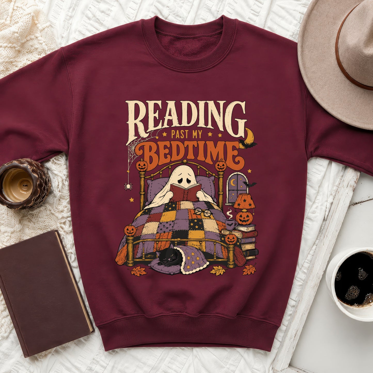 Maroon sweatshirt with ghost reading a book in a bed graphic and text "Reading Past My Bedtime".