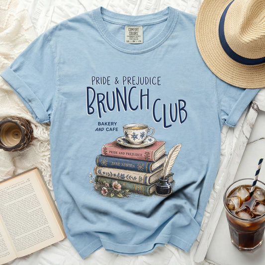 Blue t-shirt with "Pride & Prejudice Brunch Club" graphic and stack of books.