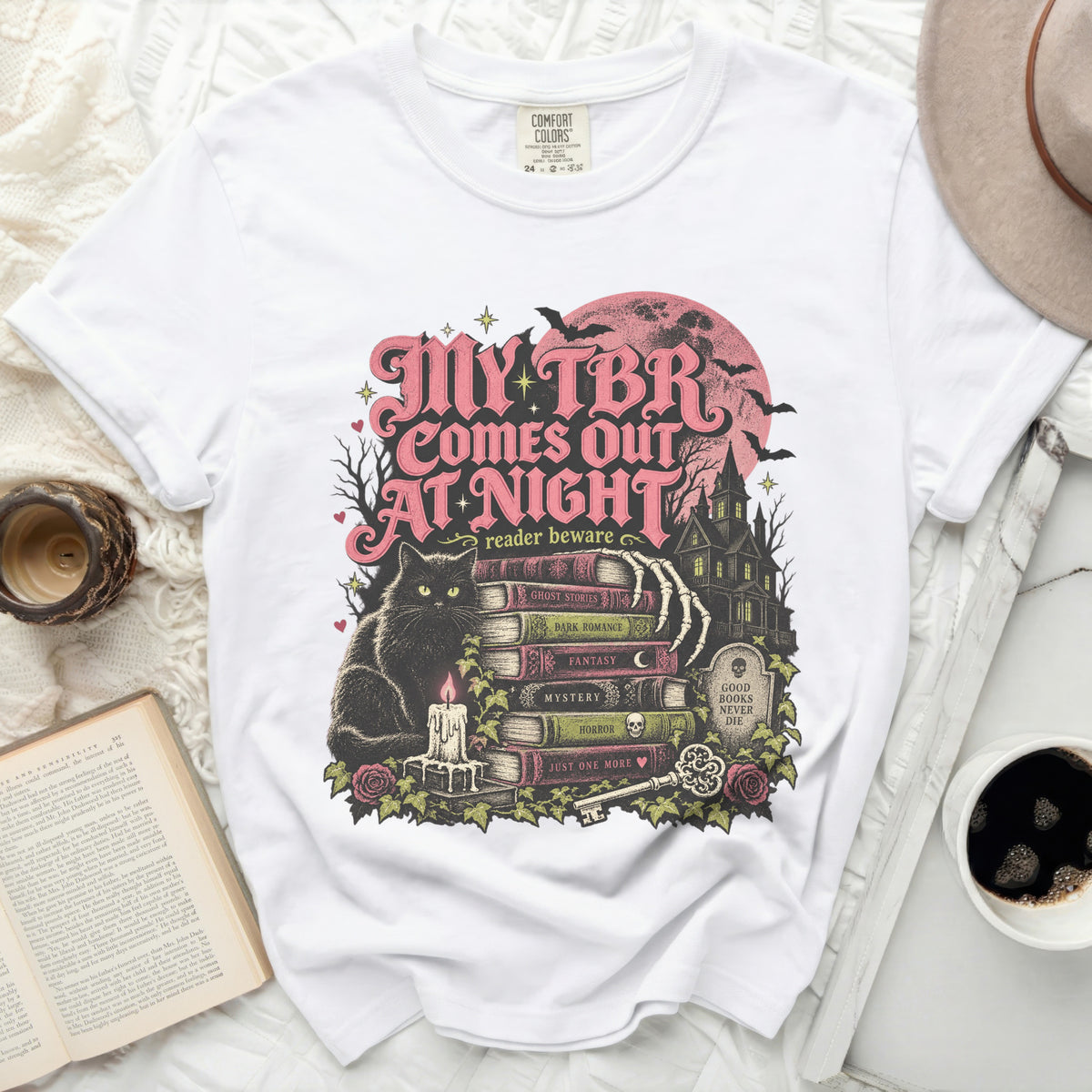 White t-shirt with "My TBR Comes Out At Night" text and spooky illustration.