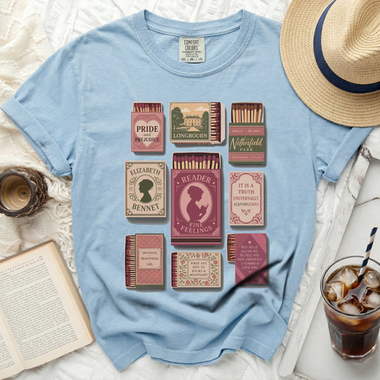 Light blue t-shirt with literary matchbox designs: Pride and Prejudice, Elizabeth Bennet, and more.