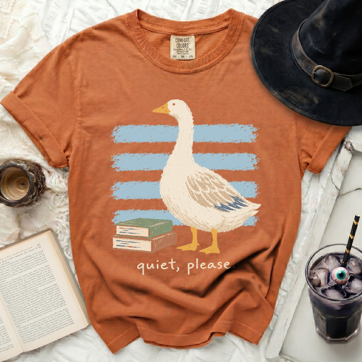 Orange t-shirt with a goose, books, and "quiet, please" text.