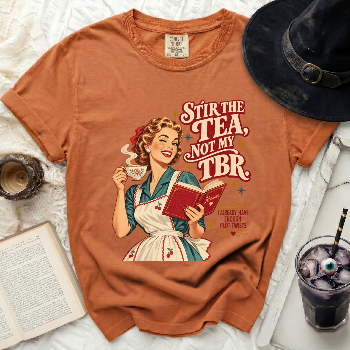 Woman winks holding tea and book, "Stir the tea, not my TBR."