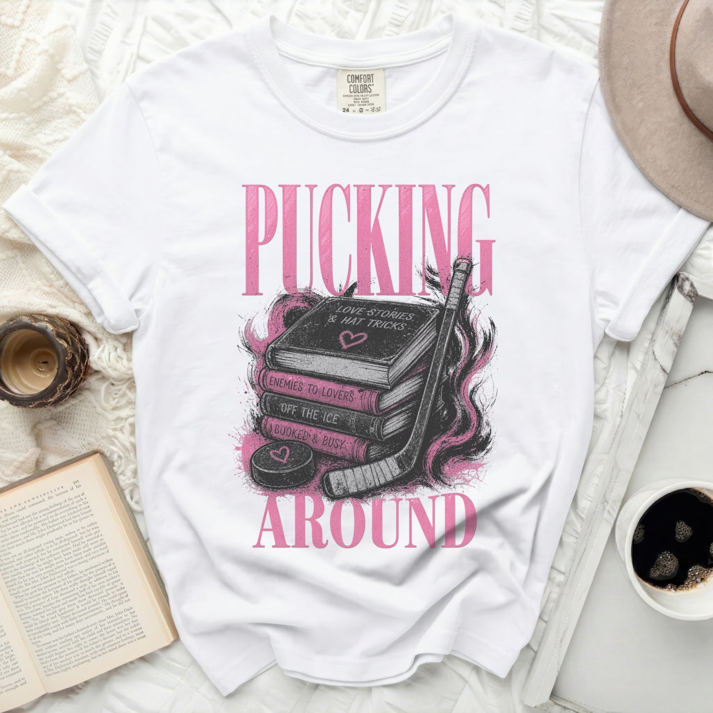 White t-shirt with "PUCKING AROUND" and book graphics.