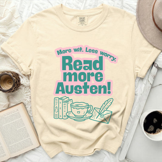Cream t-shirt with pink and teal text: "More wit. Less worry. Read more Austen!"