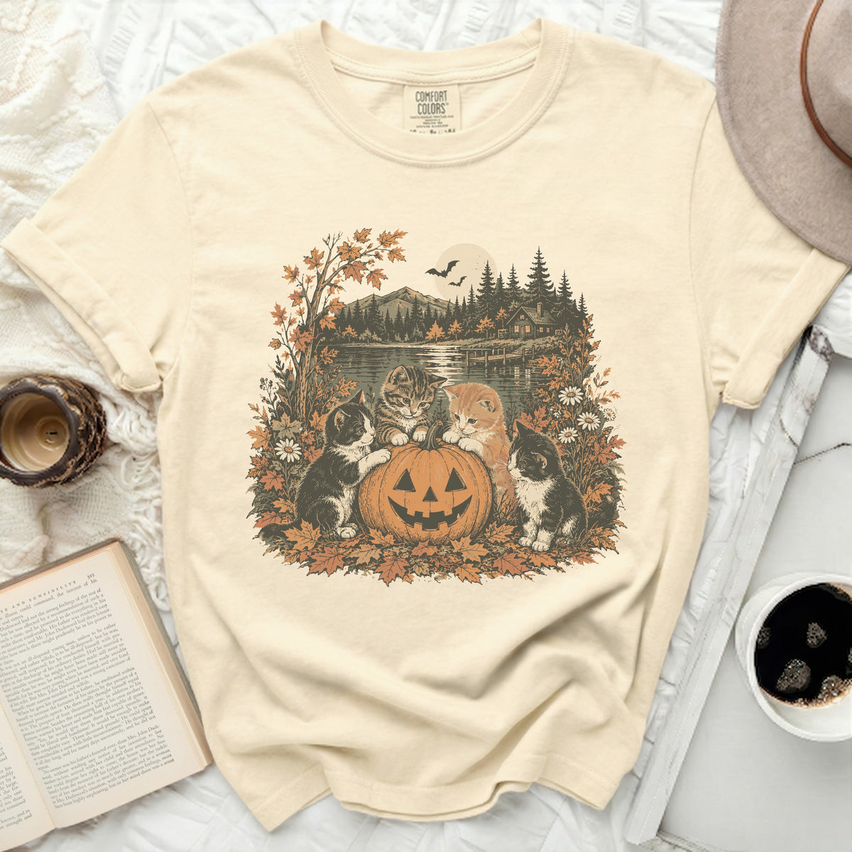 Cream t-shirt with kittens and a jack-o-lantern on an autumn landscape.
