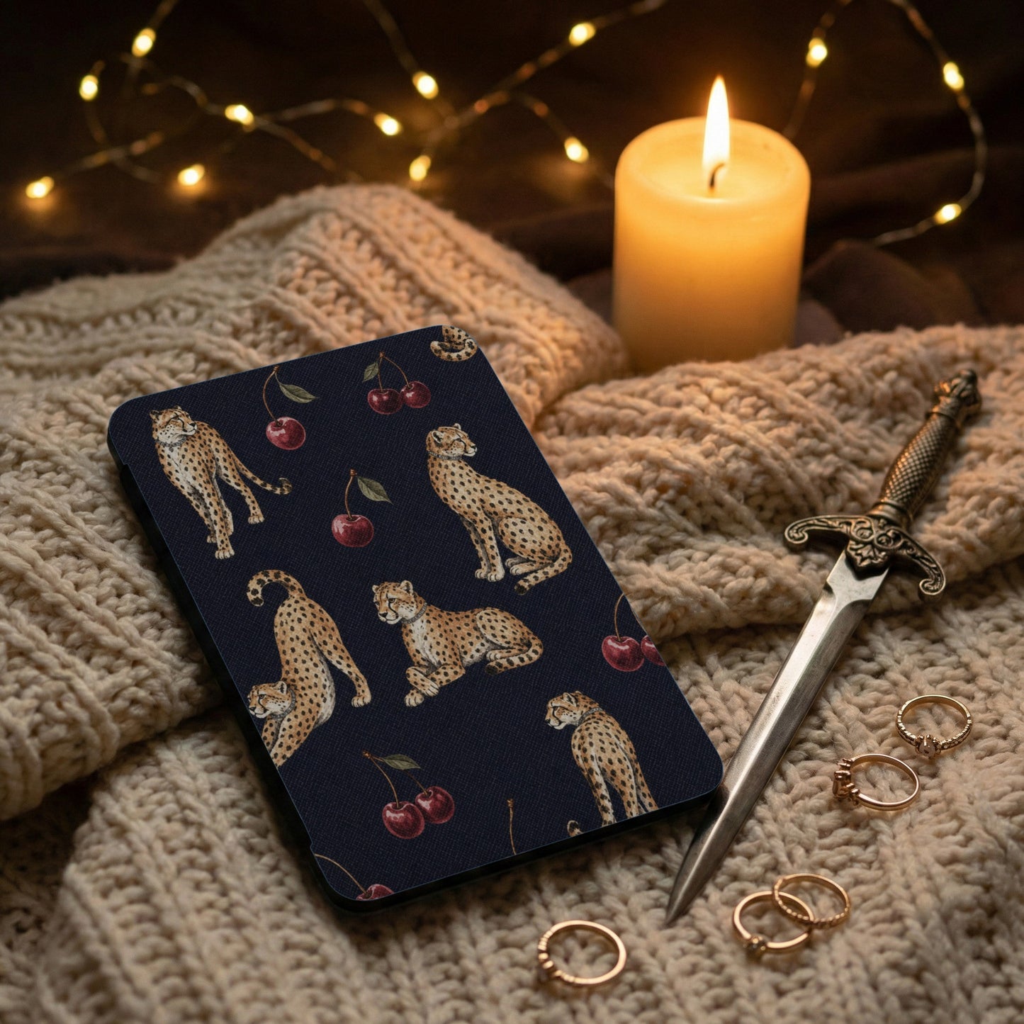 Dark blue case with cheetahs and cherries design on knitted fabric.