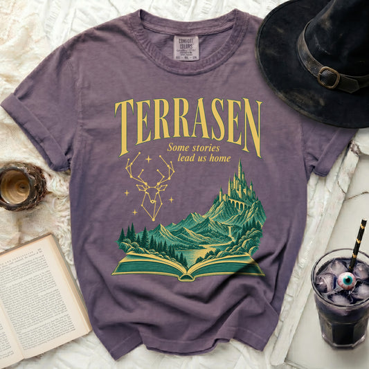 Purple t-shirt with "TERRASEN Some stories lead us home" and a castle landscape.