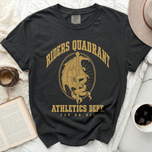 A black t-shirt with gold graphic text reading RIDERS QUADRANT ATHLETICS DEPT FLY OR DIE surrounding a sword and dragon crest.