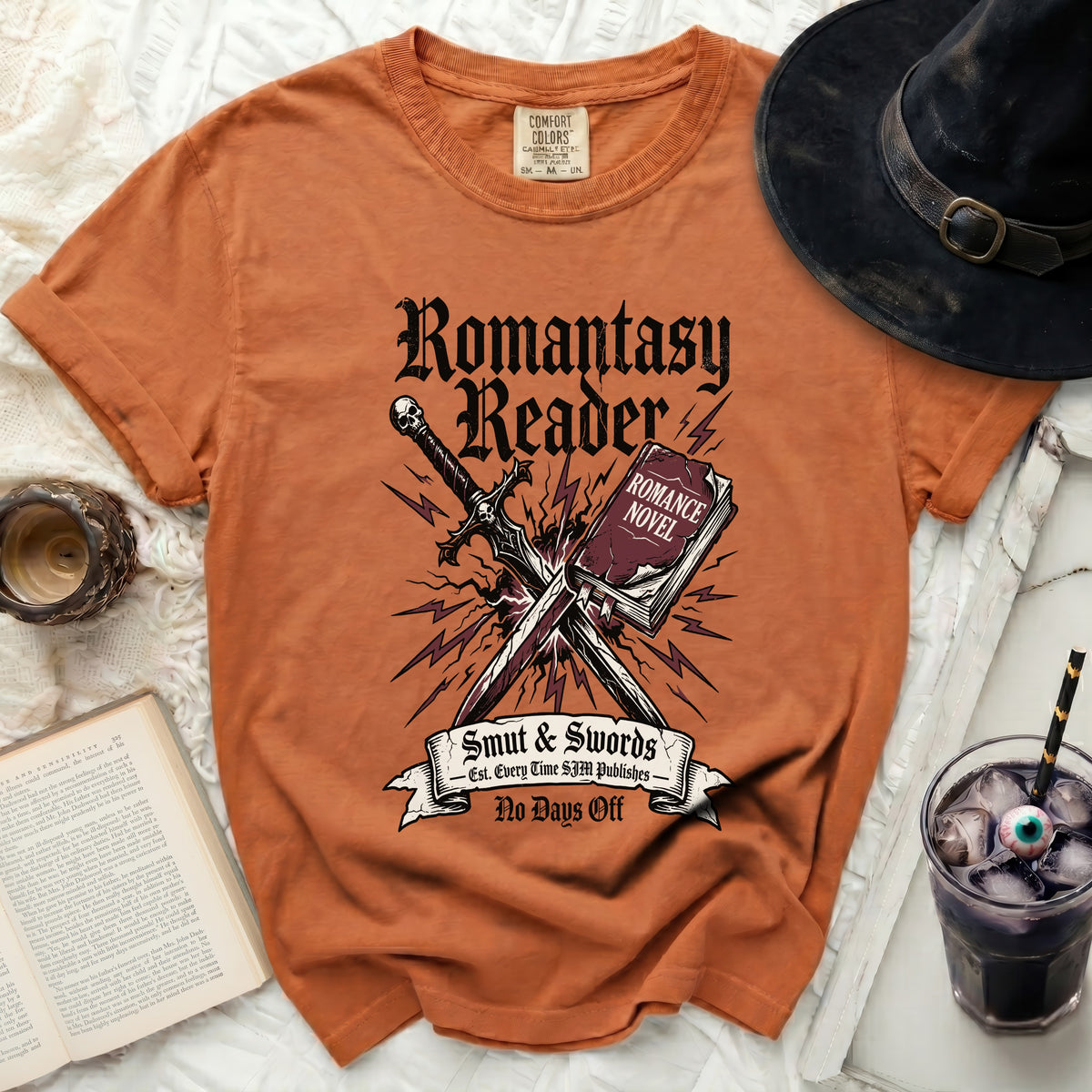 Orange t-shirt with "Romantasy Reader," sword, book, and lightning bolt graphic.
