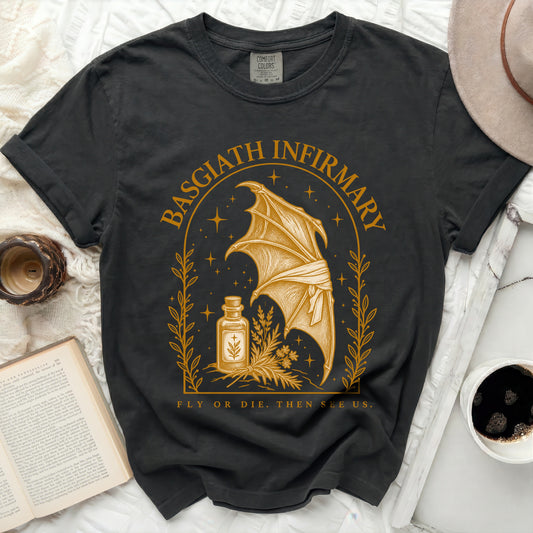 Charcoal black t-shirt featuring a gold print of a dragon wing, a potion bottle, and Basgiath Infirmary text.