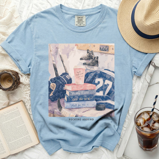 Blue t-shirt with hockey gear, books, and "Pucking Around" text.