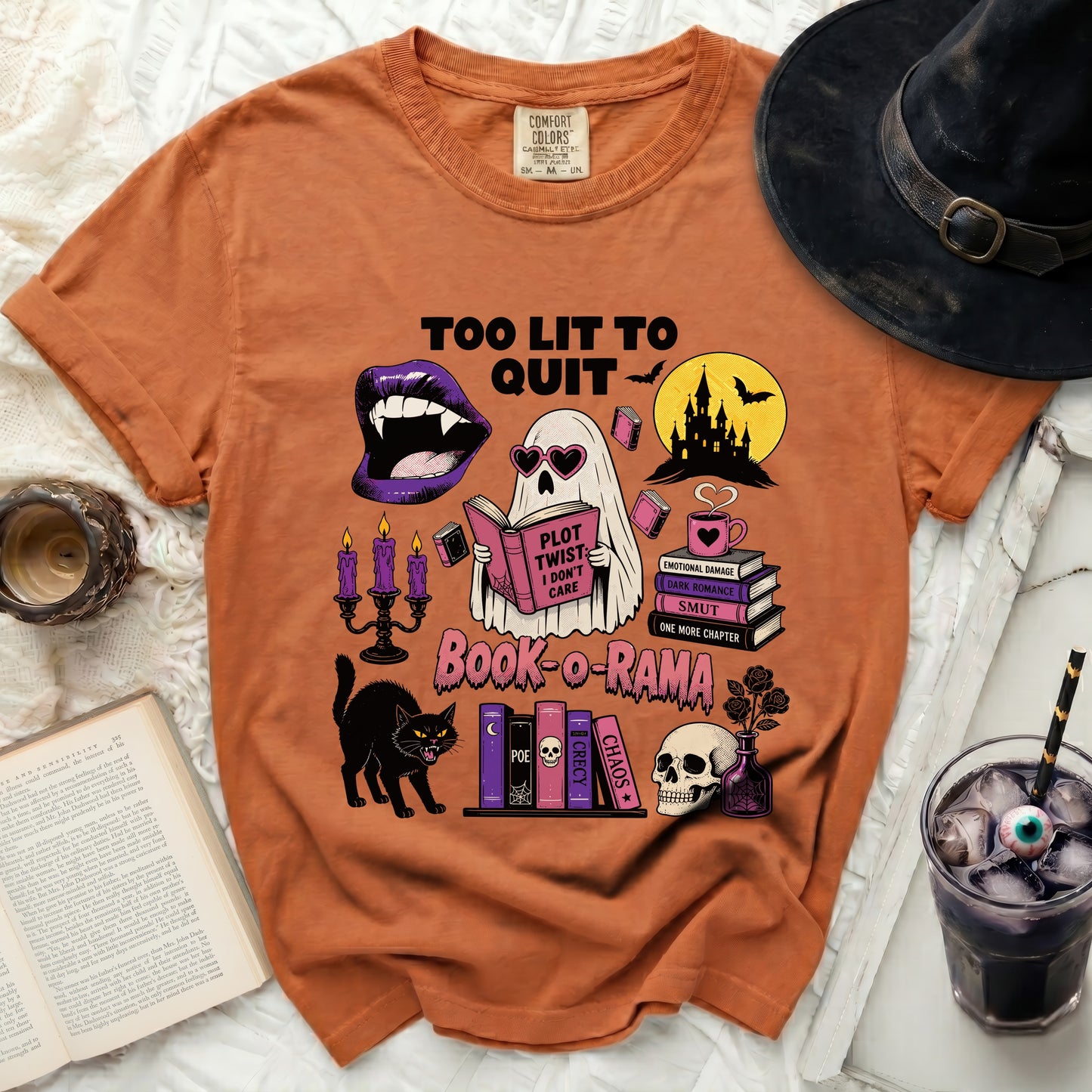 Orange t-shirt with "Too Lit To Quit" and Halloween book graphics.