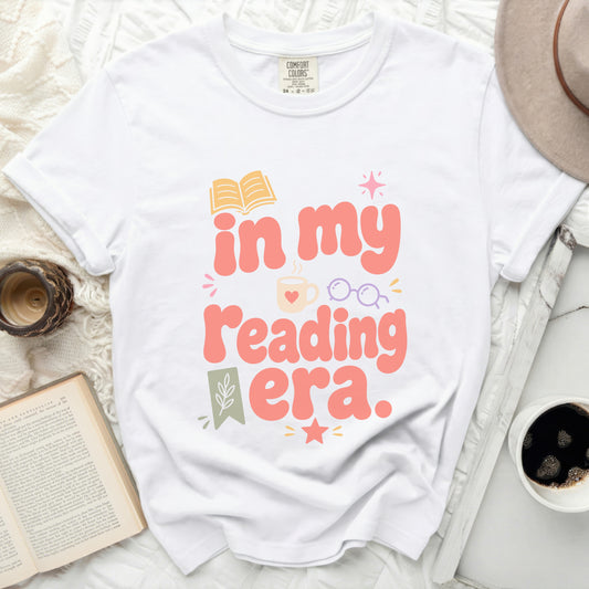 White t-shirt with "in my reading era." text and book graphic.