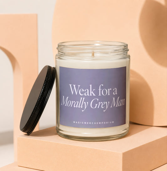 Glass candle with a black lid, featuring text "Weak for a Morally Grey Man".