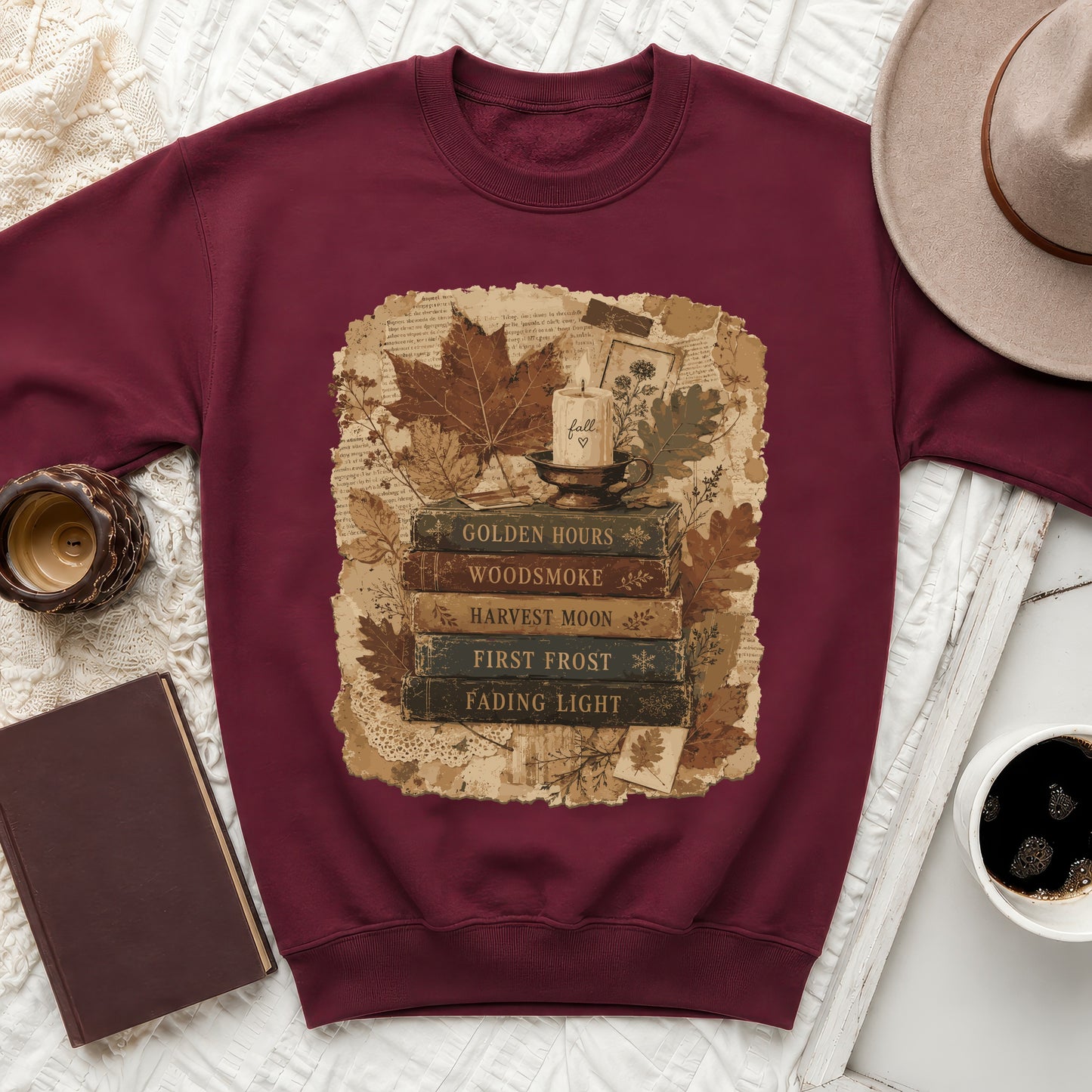 Maroon sweatshirt with a vintage book stack and fall leaf graphic.