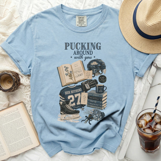 Light blue t-shirt with "Pucking Around with You" book and hockey graphics.