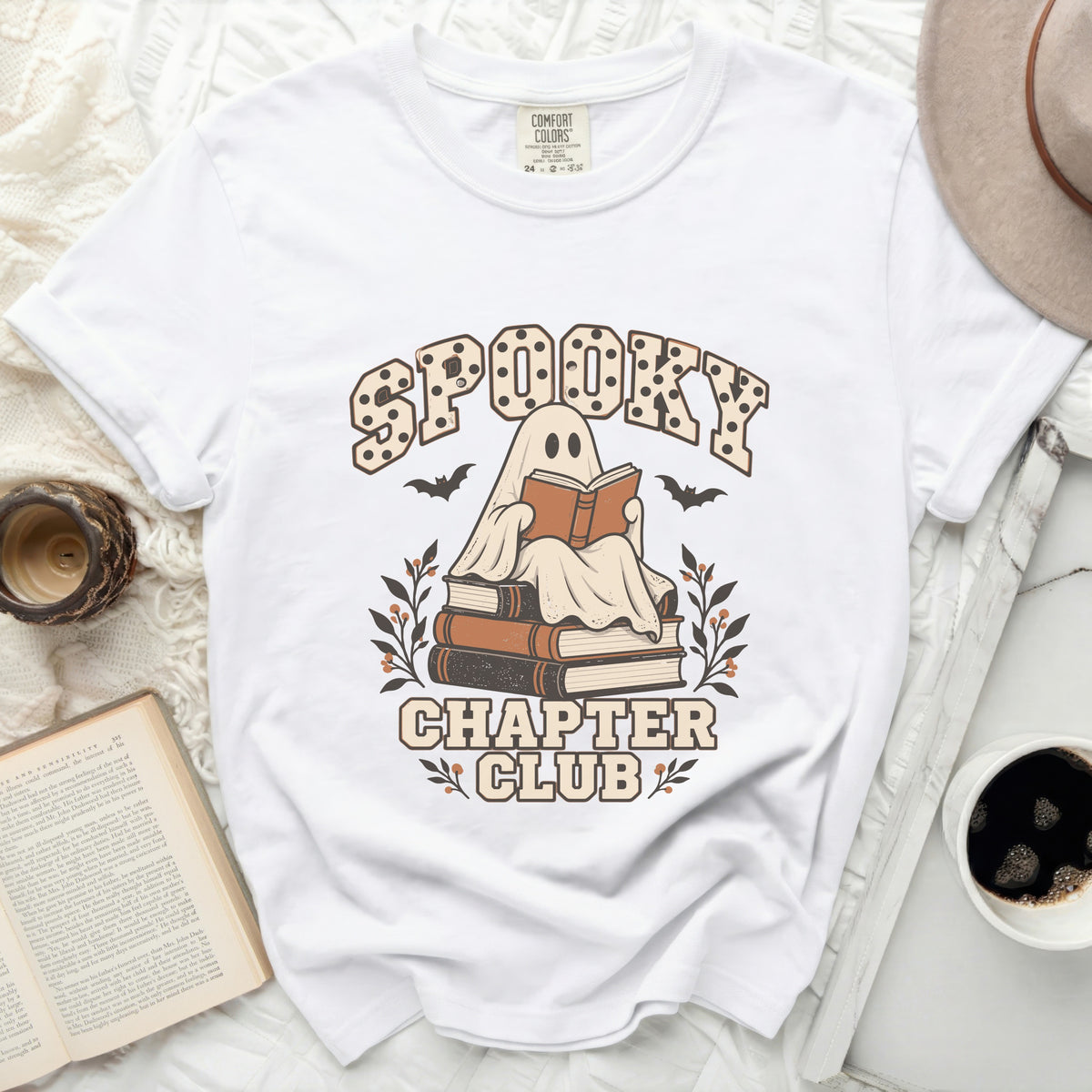 White t-shirt with a ghost reading a book and text that reads "Spooky Chapter Club".