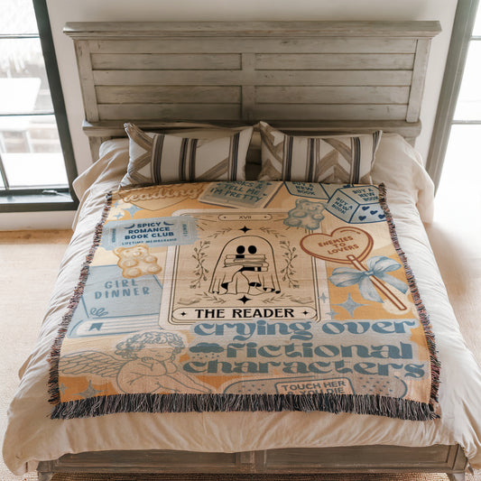 a bed with a blanket that has various text and illustrations on it, including a ghost, a book, and other decorative elements.