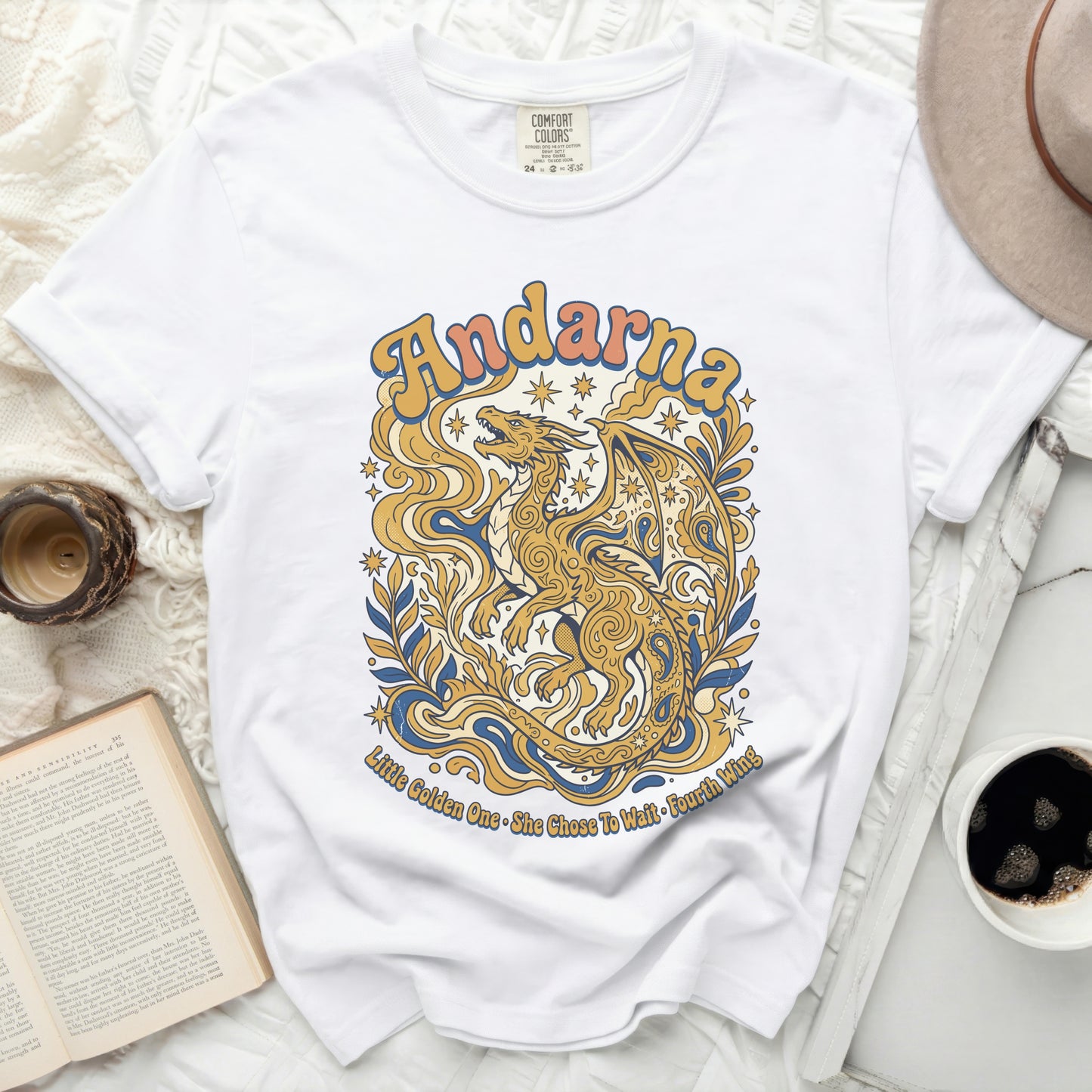 White t-shirt with gold dragon and text "Andarna" and "Little Golden One".