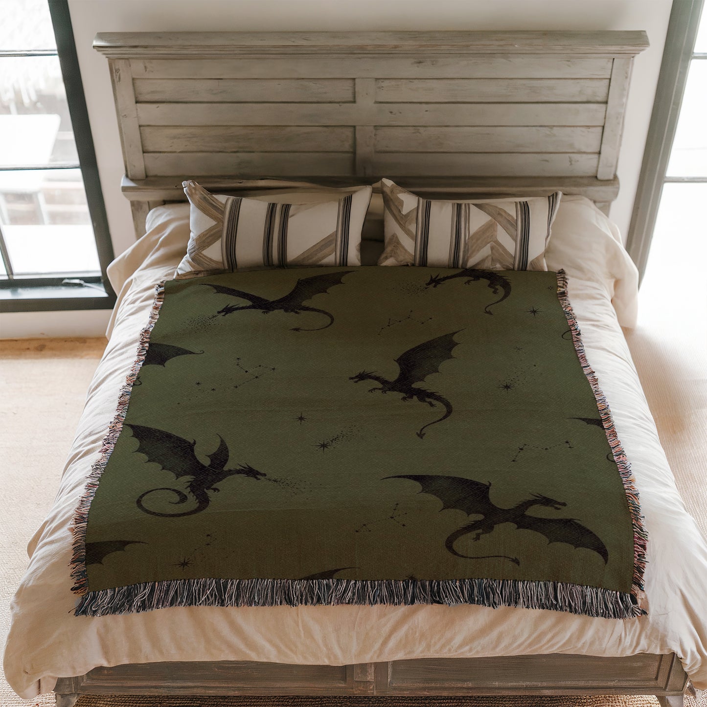 a bed with a green dragon-themed blanket and pillows.