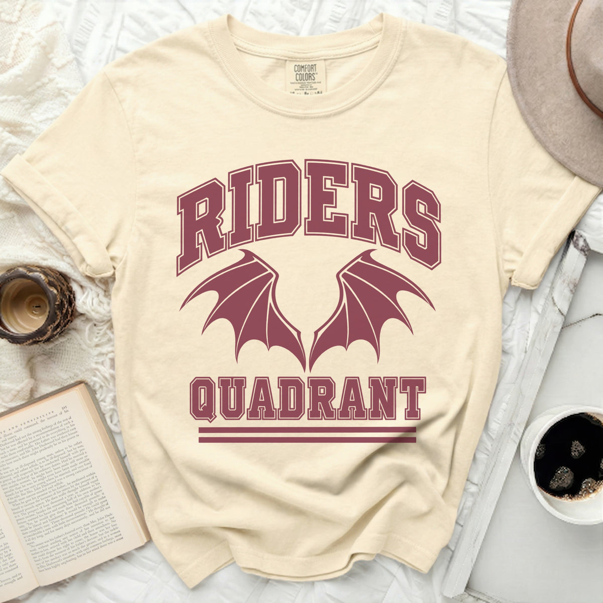 Cream t-shirt with maroon "RIDERS QUADRANT" graphic and dragon wings.