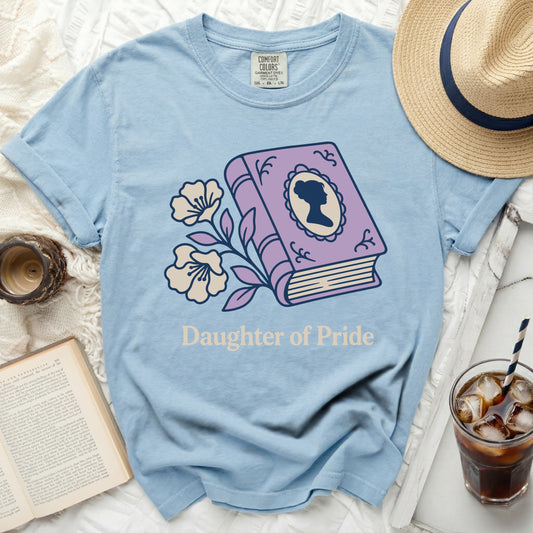Light blue t-shirt with "Daughter of Pride" text and a book illustration.