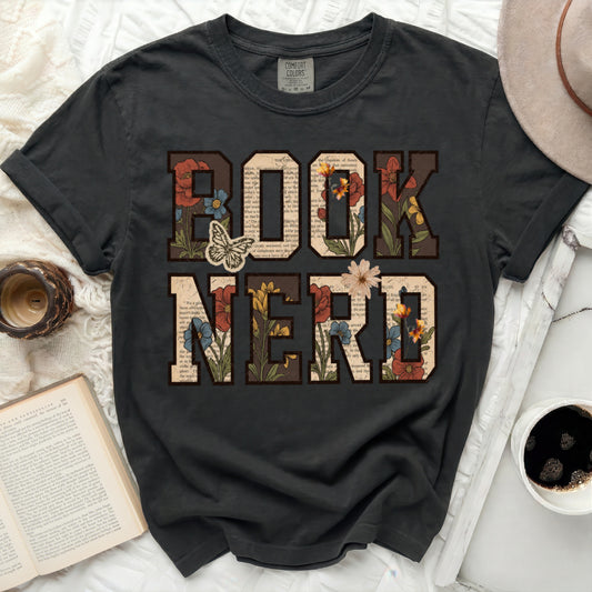 Black Comfort Colors t-shirt with "BOOK NERD" in floral letters and a butterfly.