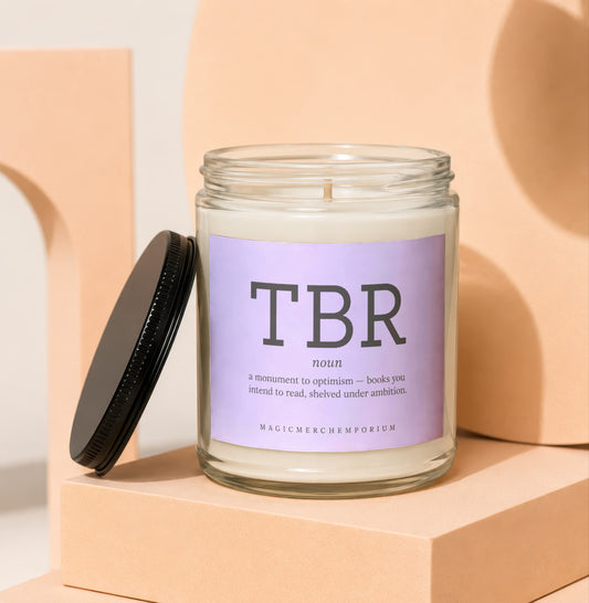 Glass candle with black lid displays "TBR" and its definition.