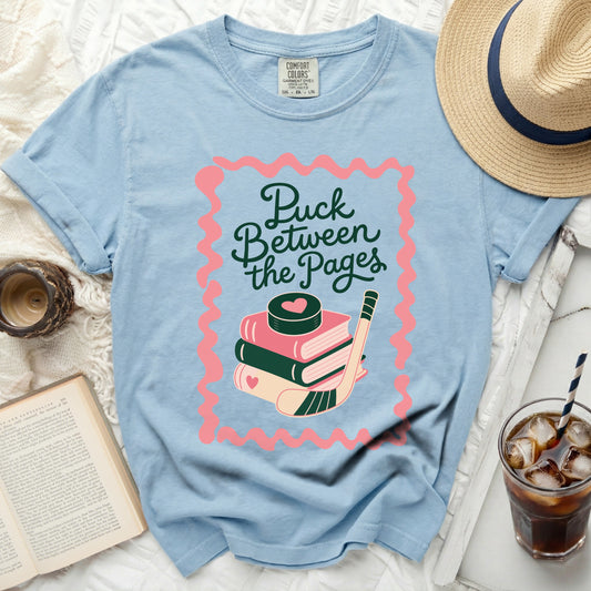 Light blue t-shirt with "Puck Between the Pages" text and hockey graphic.