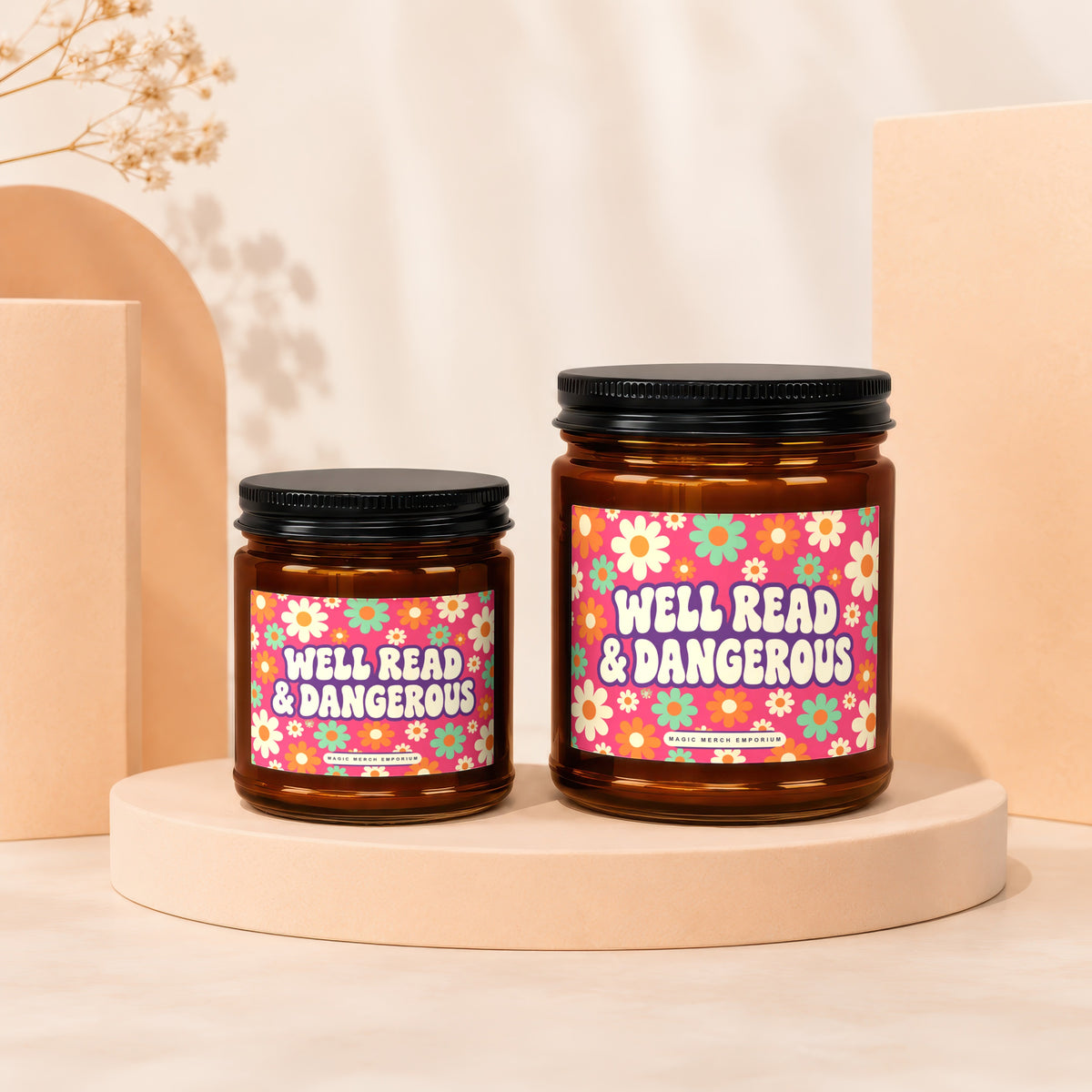 Two amber glass candles with floral labels reading "Well Read & Dangerous."
