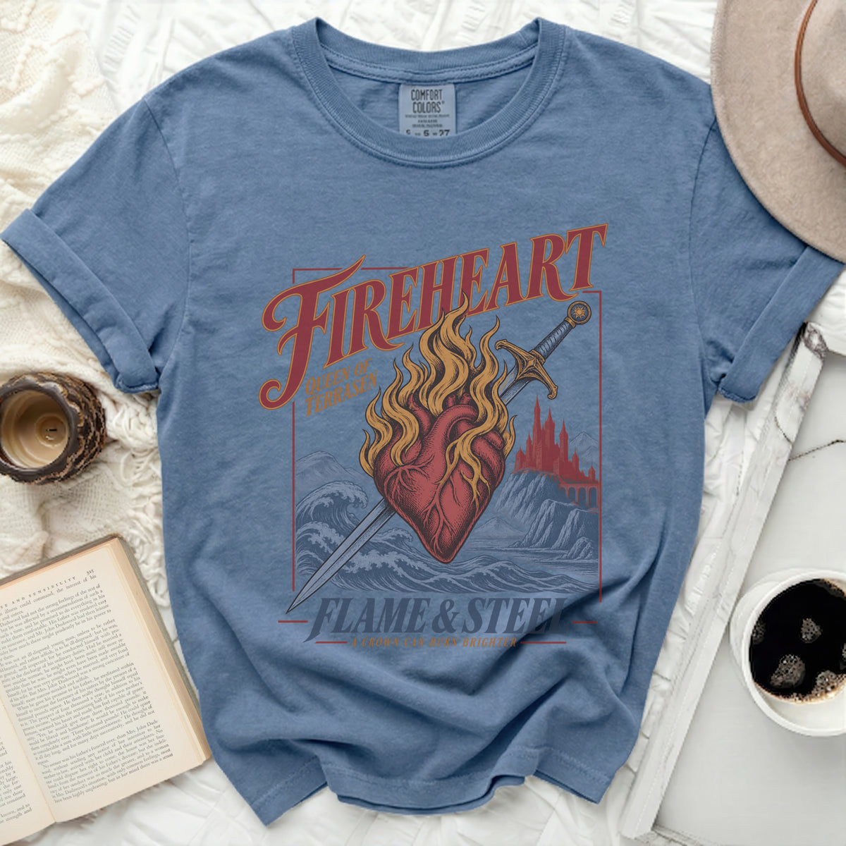 Blue t-shirt with "Fireheart Queen of Terrasen Flame & Steel A Crown Can Burn Brighter" graphic.