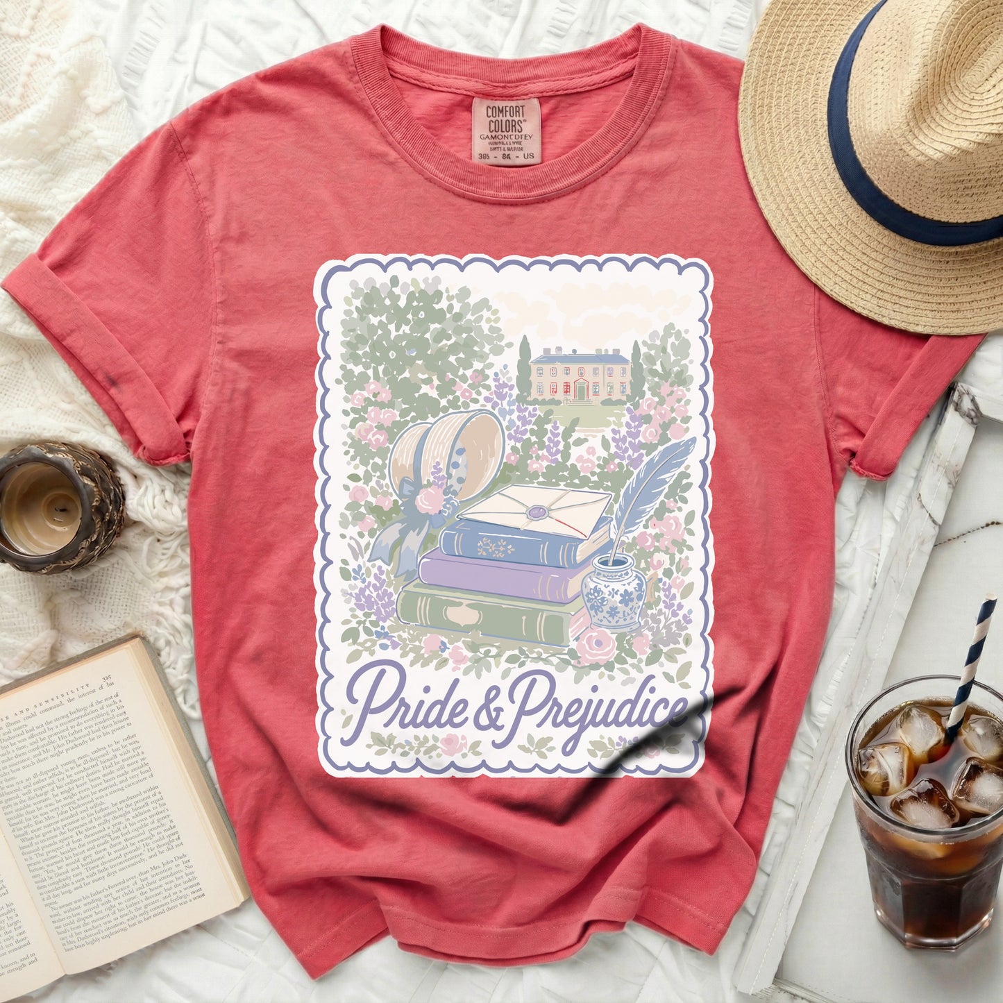 Coral t-shirt with "Pride & Prejudice" graphic featuring books, quill, and manor.