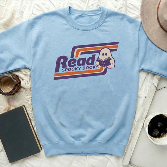Light blue sweatshirt with "Read Spooky Books" ghost graphic and retro stripes.