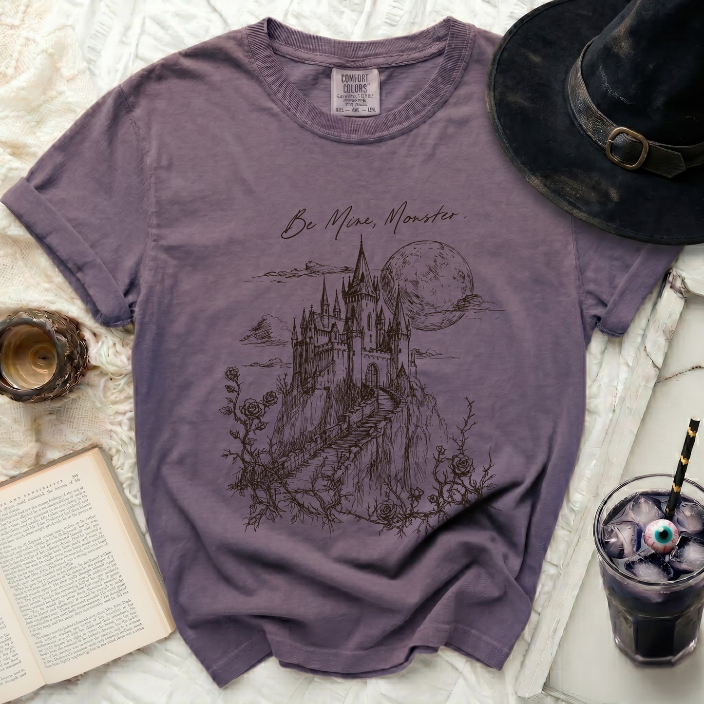 Purple t-shirt with "Be Mine, Monster." text and castle graphic.