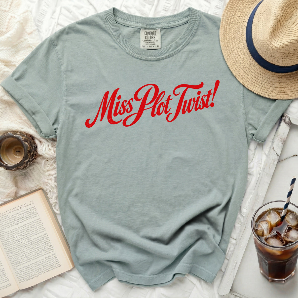 Light teal t-shirt with red "Miss Plot Twist!" text.