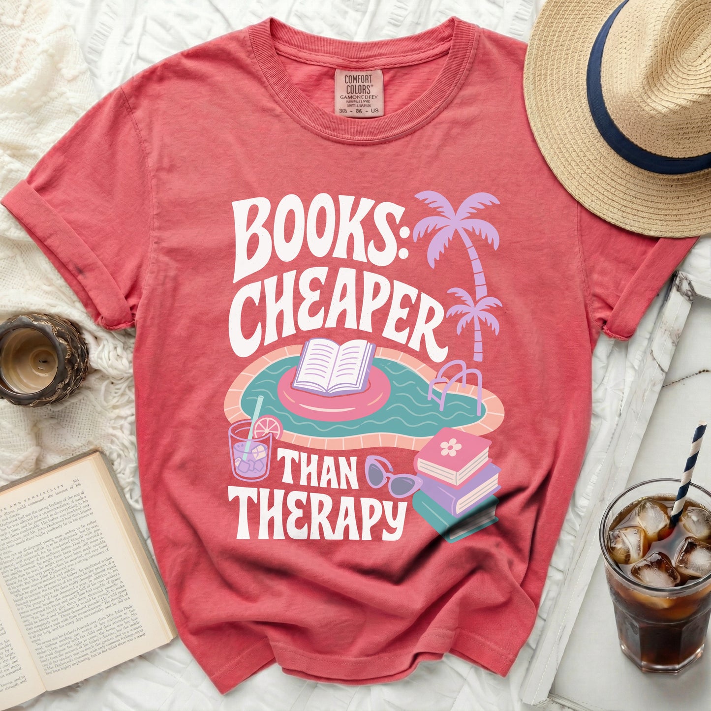 Coral t-shirt with "Books: Cheaper Than Therapy" text and pool graphic.