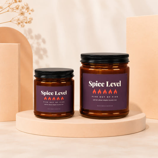 Two brown glass candles with dark lids, labels read "Spice Level" and "Magic Merch Emporium".