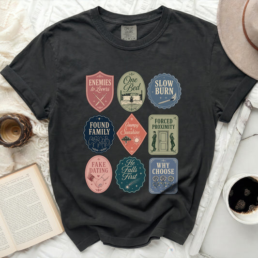 Black t-shirt with nine romance novel-themed graphic badges.