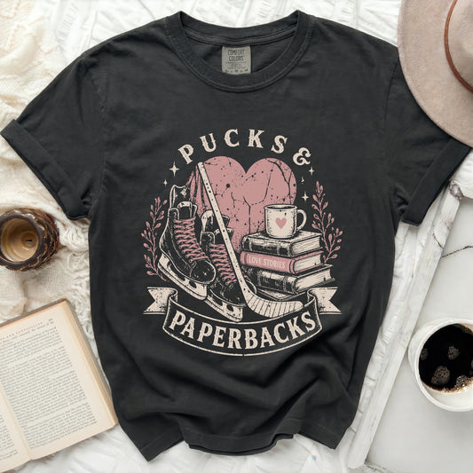 Black t-shirt with "Pucks & Paperbacks" graphic and books.