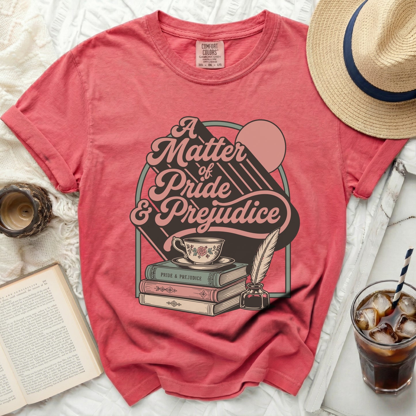 Coral t-shirt with "A Matter of Pride & Prejudice" graphic and literary elements.