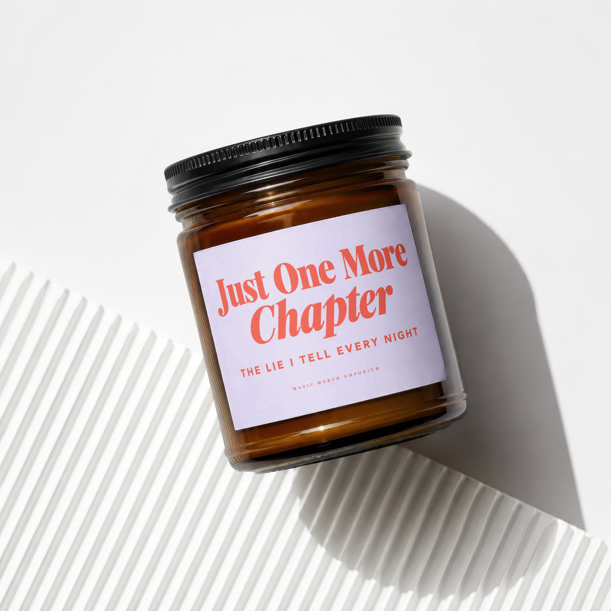 Amber jar candle with lavender label reading "Just One More Chapter."