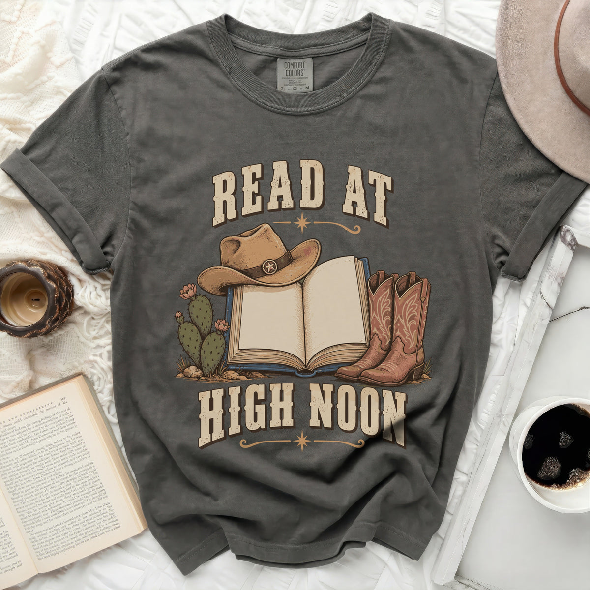 T-shirt with cowboy hat, boots, and book graphic saying "READ AT HIGH NOON".