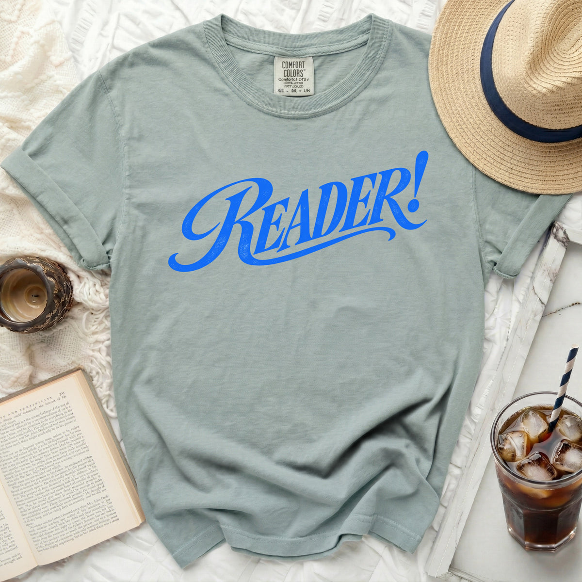 T-shirt with blue "READER!" text, straw, hat, and book.