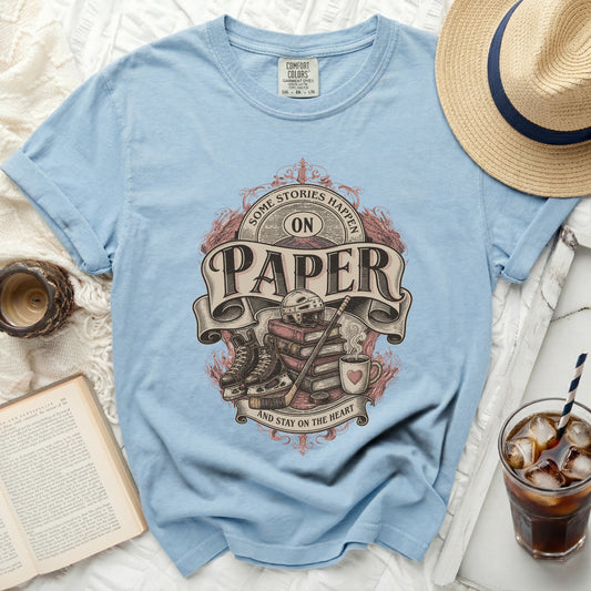 Light blue t-shirt with "Some Stories Happen on Paper and Stay on the Heart" text and ice hockey graphics.