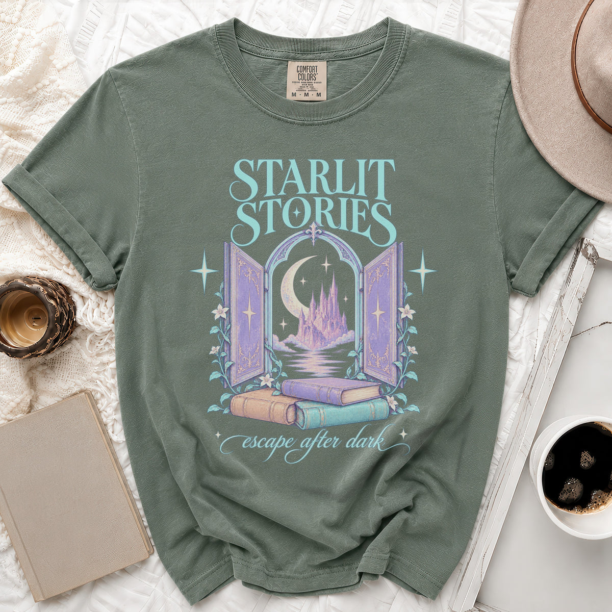Green t-shirt with "Starlit Stories" and castle graphic, and text "escape after dark".
