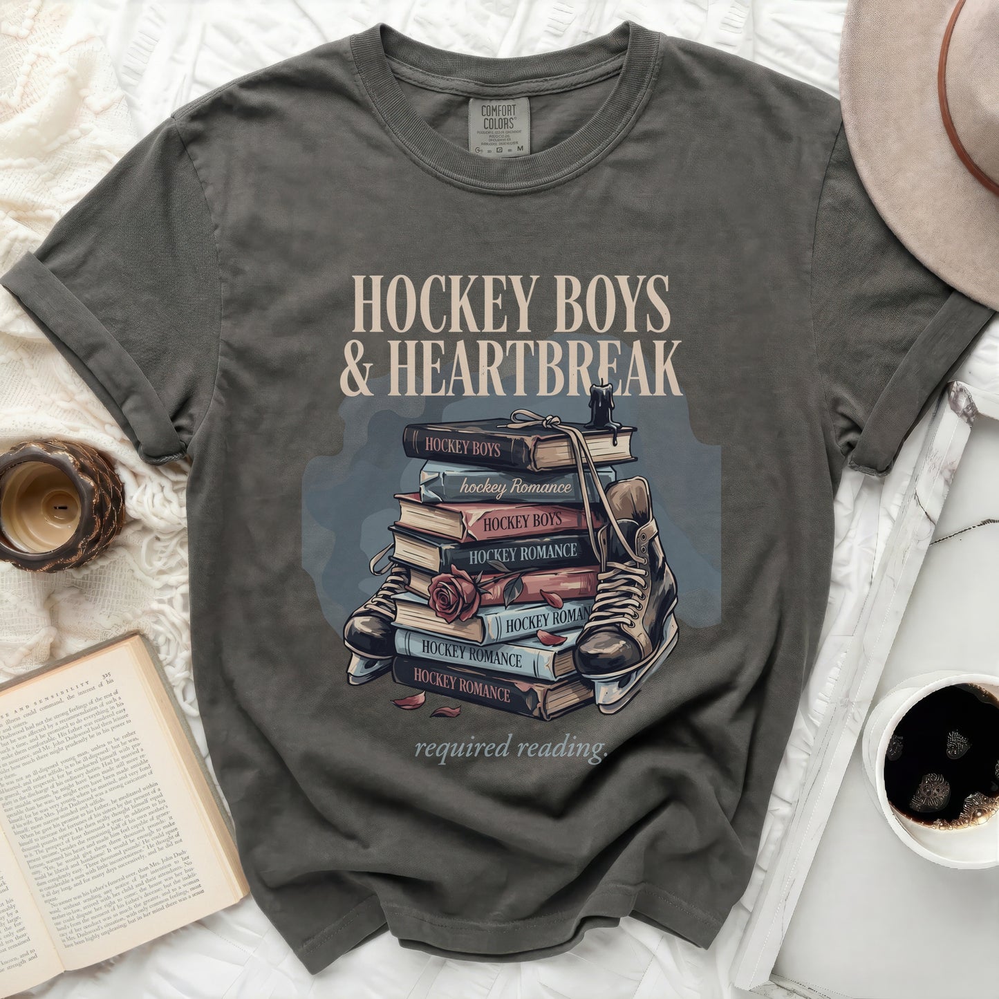 T-shirt graphic featuring books titled "Hockey Boys & Heartbreak" and skates.