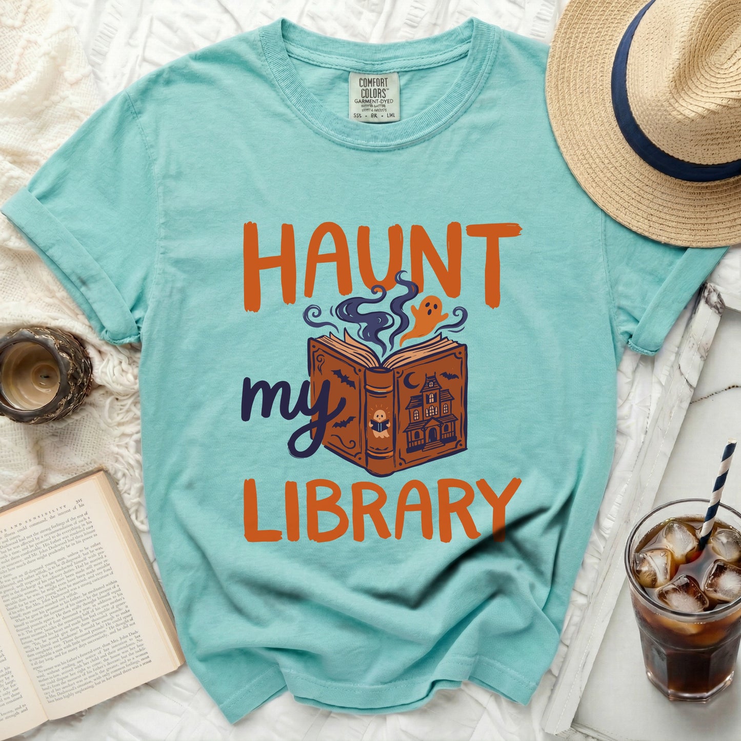 Teal t-shirt with "Haunt my Library" Halloween book graphic.