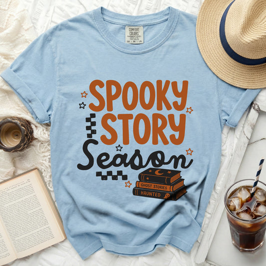 Light blue t-shirt with "Spooky Story Season" graphic and stacked books.