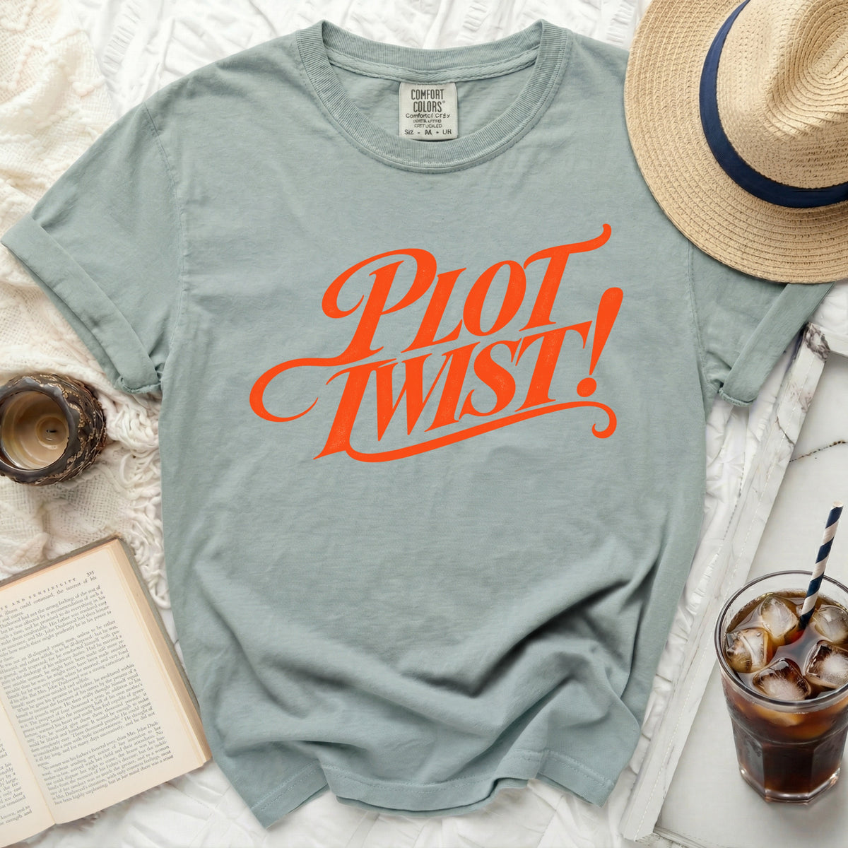 Light blue t-shirt with orange "PLOT TWIST!" graphic, size M.